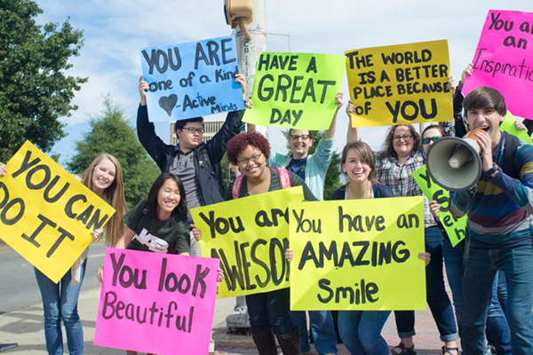 students holding signs on side of street