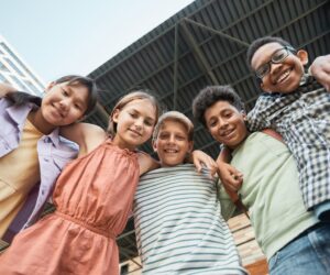 Kids Arms Around Each Other while Smiling at the Camera