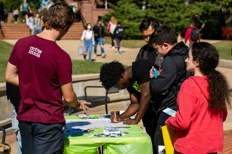 Photo of students outside signing up at a table