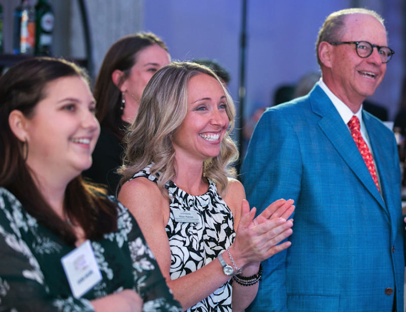 A group of people clapping at a fundraiser