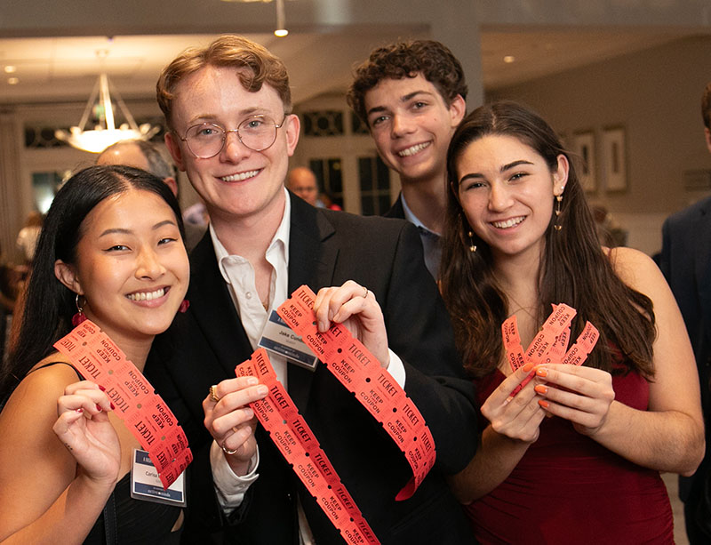 A group of people holding up reward tickets posing for the camera