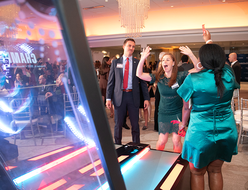 People looking happy while playing skee ball game